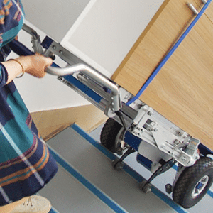 Stair climbing equipment hire being used to transport furniture up stairs.