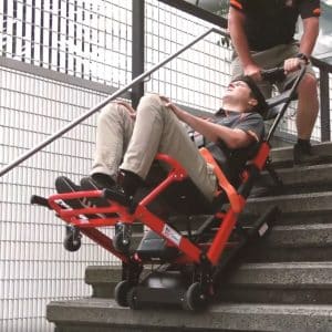 Electric stair climber chair transporting individual downstairs, illustrating advanced types of stair climbers for emergencies.