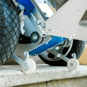 Motorised Stair Climber wheels with support rollers safely moving heavy load up concrete step.