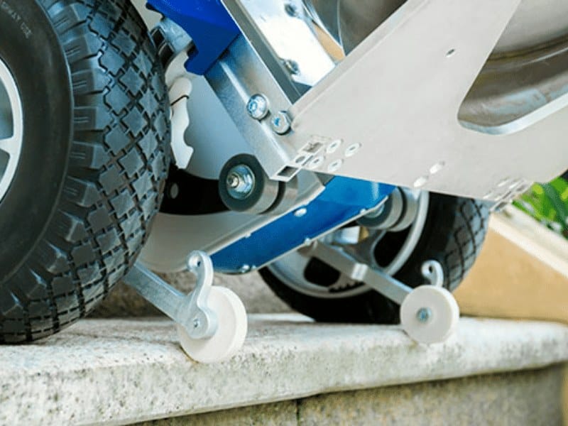 Motorised Stair Climber wheels with support rollers safely moving heavy load up concrete step.