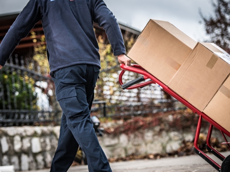 stair climber trolley hire: heavy wooden crate strapped onto stair-climbing trolley with stabilising legs.